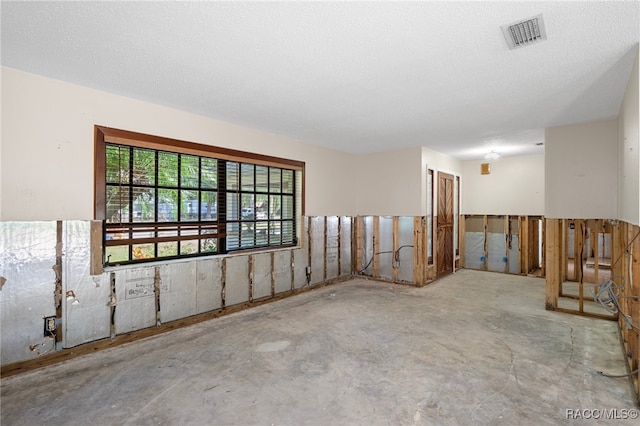 unfurnished room with a textured ceiling