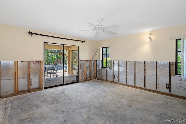 empty room with concrete floors and ceiling fan