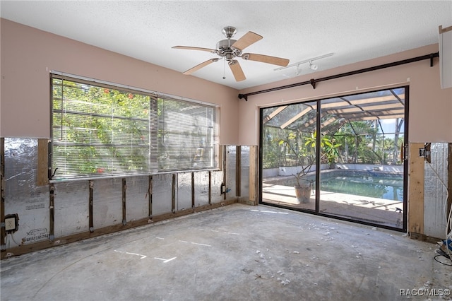 unfurnished room with a textured ceiling, plenty of natural light, and ceiling fan