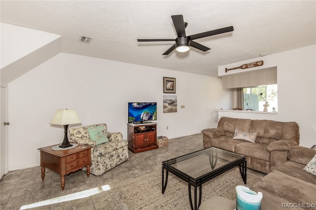 living room featuring ceiling fan and a textured ceiling