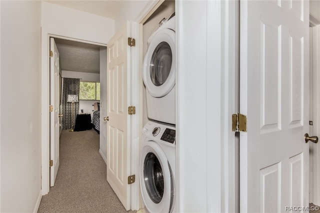 clothes washing area with light colored carpet and stacked washer and clothes dryer