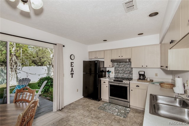 kitchen featuring stainless steel electric stove, black refrigerator, sink, ceiling fan, and tasteful backsplash