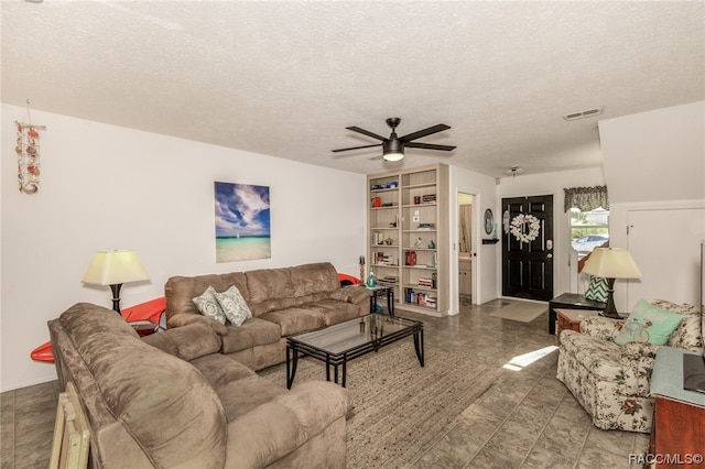 living room featuring a textured ceiling and ceiling fan