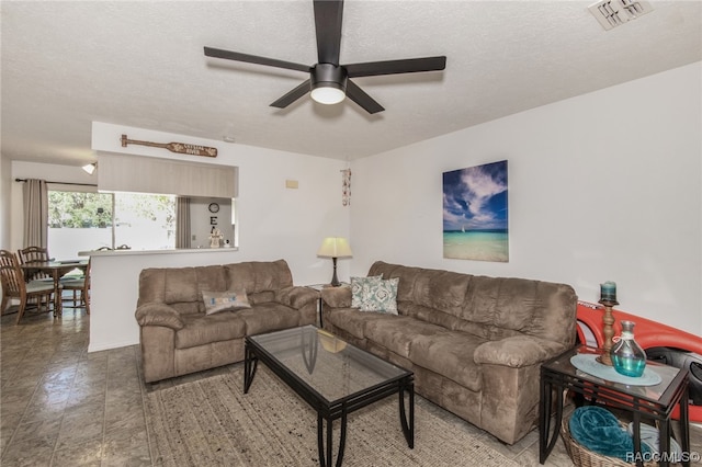 living room with ceiling fan and a textured ceiling