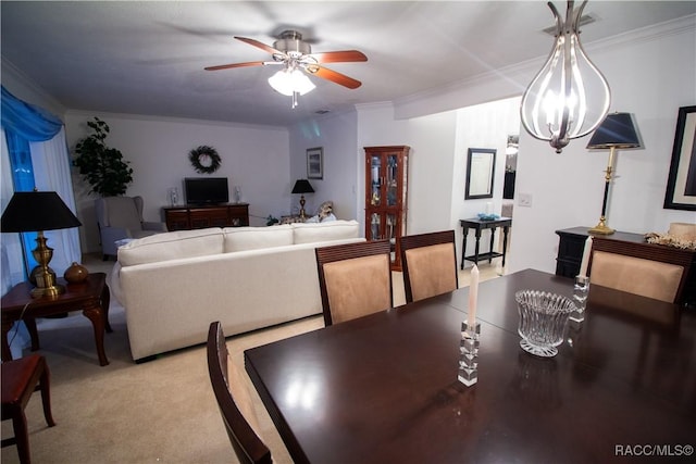 carpeted dining room with crown molding and ceiling fan with notable chandelier