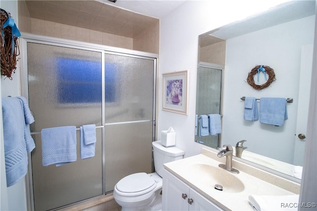 bathroom with toilet, a shower with door, and vanity