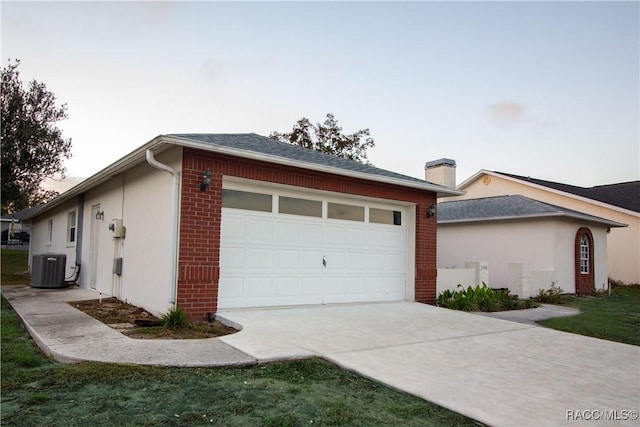 property exterior at dusk featuring central AC and a garage