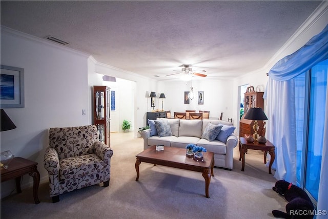 living room featuring carpet floors, a textured ceiling, ornamental molding, and ceiling fan