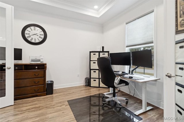 office area featuring light hardwood / wood-style floors, a raised ceiling, and crown molding