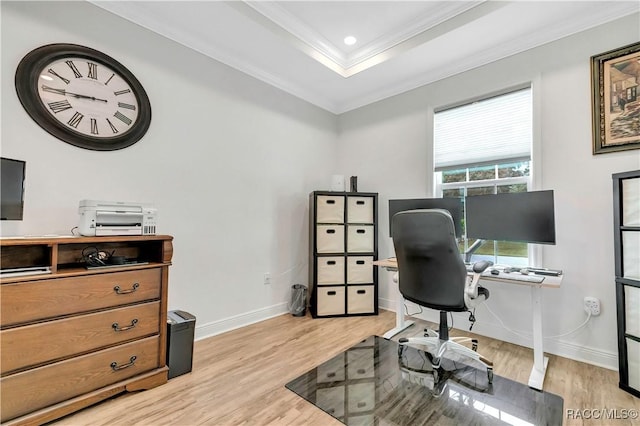 home office featuring light wood-type flooring, crown molding, and a tray ceiling