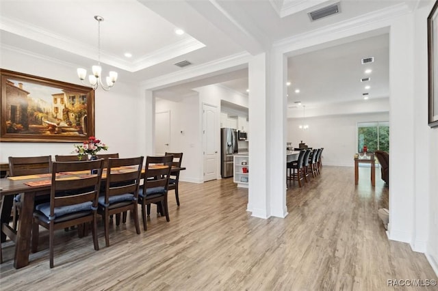 dining area featuring a chandelier, light wood-type flooring, and crown molding