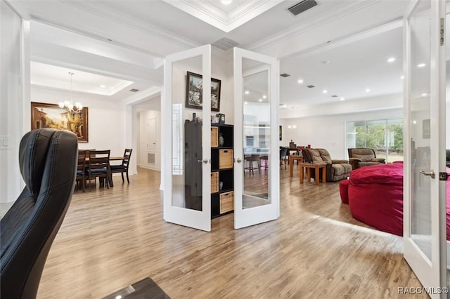 interior space with crown molding, french doors, a chandelier, and light wood-type flooring