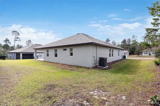 back of property featuring a lawn and central air condition unit