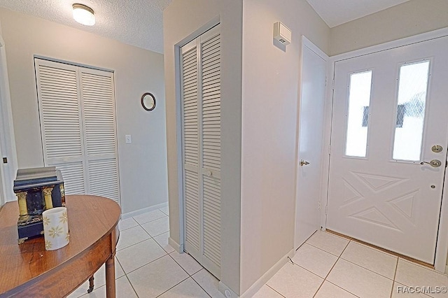 tiled entryway with a textured ceiling