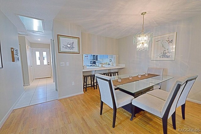 dining area featuring light hardwood / wood-style floors and a chandelier