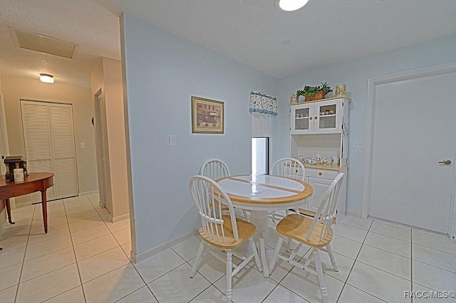 dining area featuring light tile patterned floors and a textured ceiling