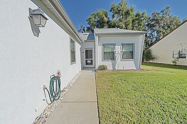 doorway to property with a yard