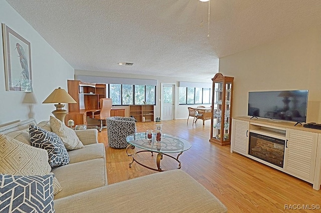 living room with a textured ceiling and light wood-type flooring