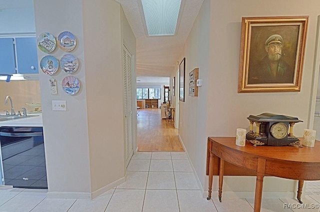 hallway with light tile patterned flooring and sink