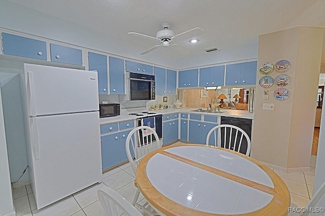 kitchen with sink, light tile patterned floors, black appliances, and blue cabinets