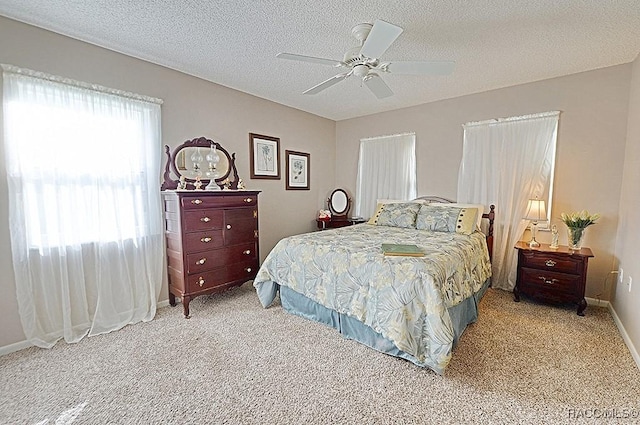 bedroom featuring ceiling fan, light colored carpet, and a textured ceiling