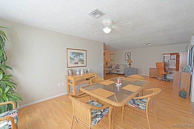 dining area featuring a textured ceiling, light hardwood / wood-style flooring, and ceiling fan