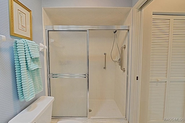 bathroom featuring toilet and an enclosed shower