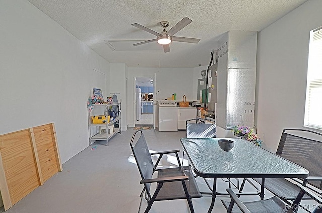 dining area featuring ceiling fan, concrete floors, a textured ceiling, and washing machine and clothes dryer