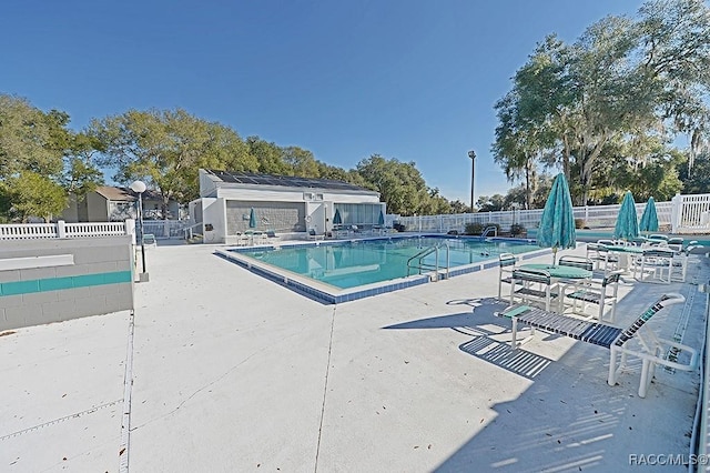 view of pool with an outbuilding and a patio