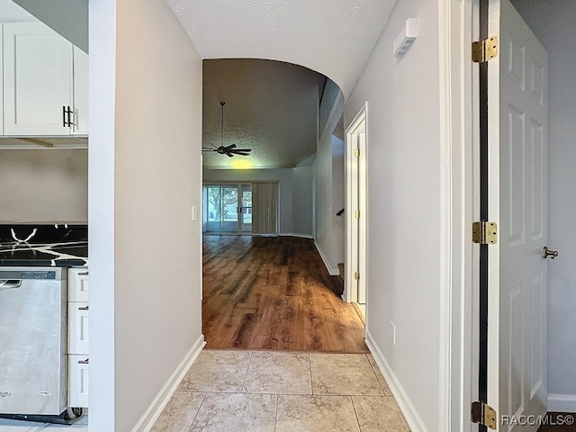 corridor featuring light hardwood / wood-style floors and a textured ceiling