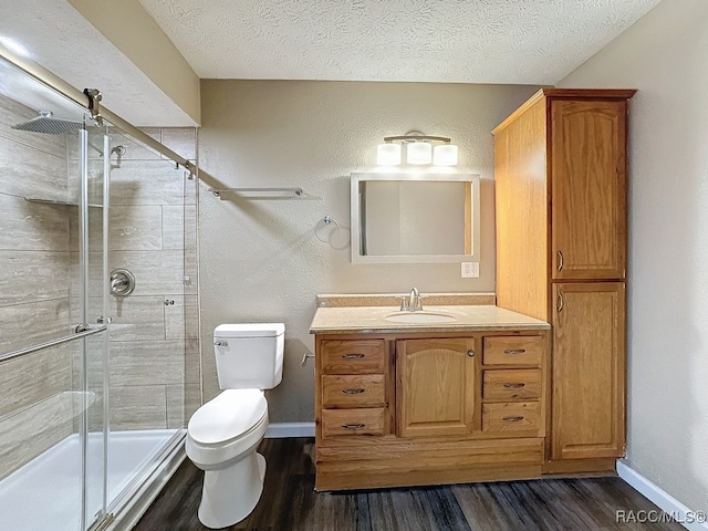 bathroom with walk in shower, vanity, a textured ceiling, and hardwood / wood-style flooring