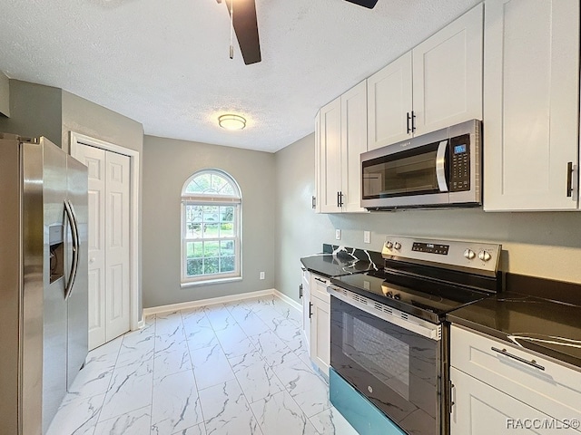 kitchen featuring ceiling fan, white cabinets, a textured ceiling, and appliances with stainless steel finishes