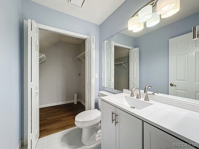 bathroom featuring a textured ceiling, vanity, hardwood / wood-style flooring, and toilet