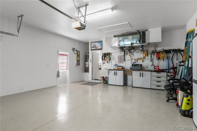 garage featuring a workshop area, a garage door opener, and water heater