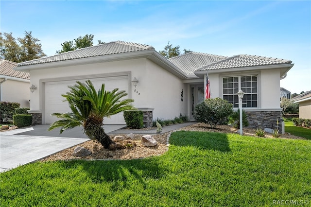 mediterranean / spanish-style house with a garage and a front lawn