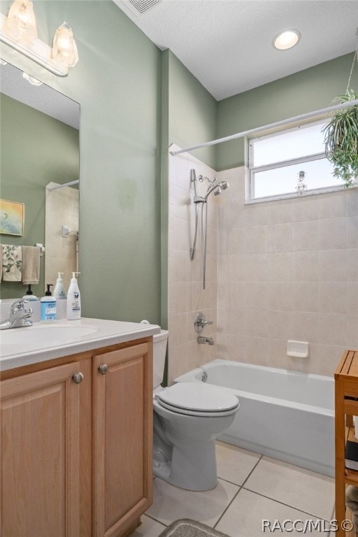 full bathroom with toilet, vanity, tile patterned floors, and tiled shower / bath