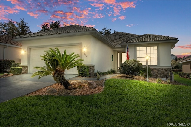 mediterranean / spanish house featuring a yard and a garage