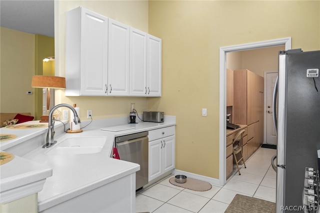 kitchen featuring sink, white cabinets, light tile patterned floors, and appliances with stainless steel finishes