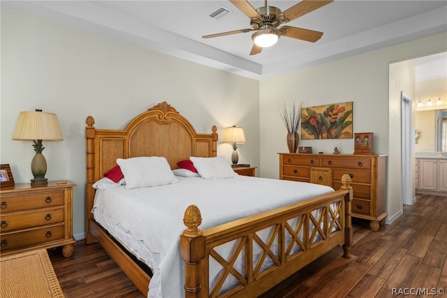 bedroom featuring dark hardwood / wood-style floors, ceiling fan, and connected bathroom