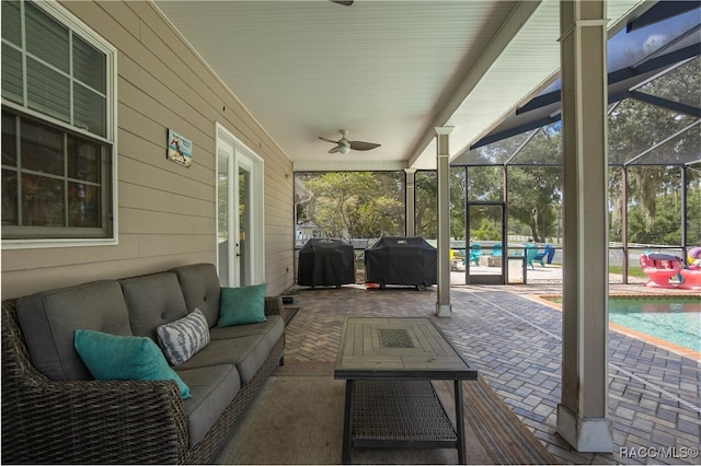 view of patio / terrace with ceiling fan, a grill, an outdoor living space, and glass enclosure