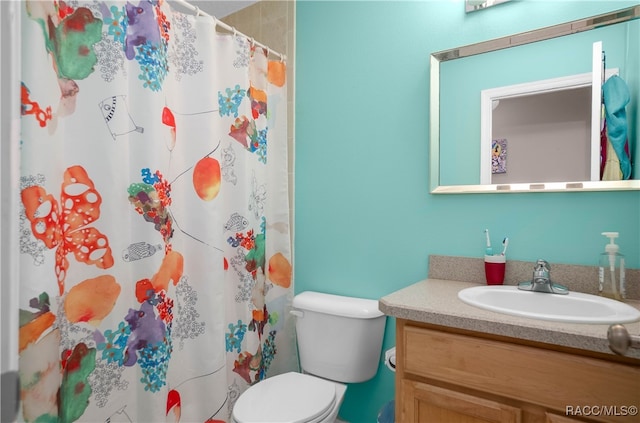 bathroom featuring a shower with curtain, vanity, and toilet