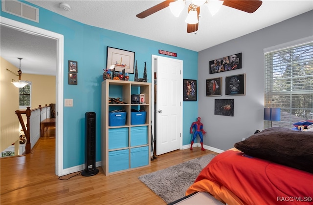 bedroom featuring wood-type flooring, a textured ceiling, and ceiling fan