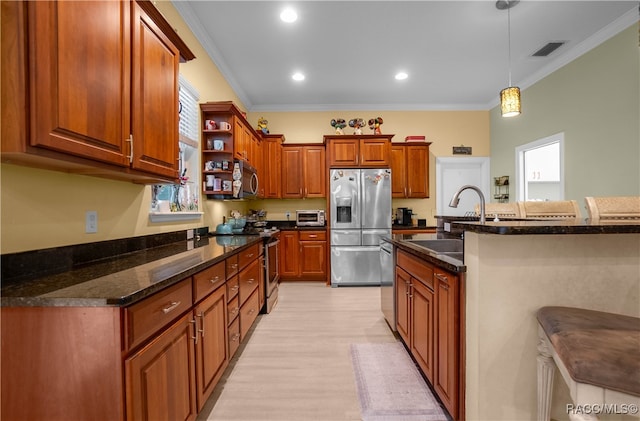 kitchen featuring decorative light fixtures, light wood-type flooring, stainless steel appliances, and ornamental molding