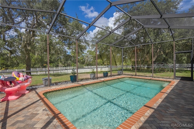 view of pool featuring glass enclosure and a patio area