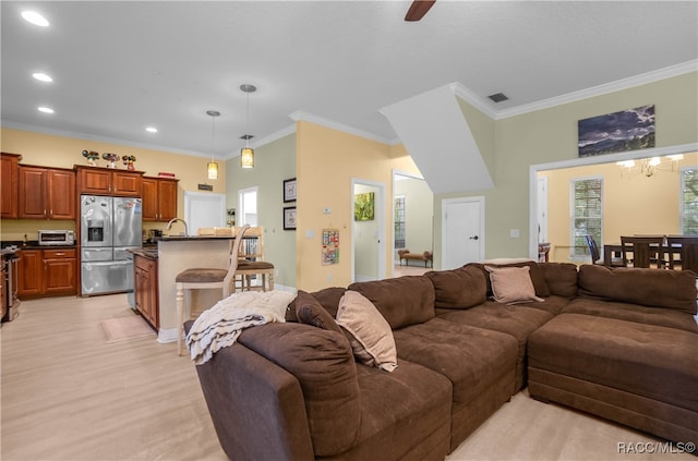 living room featuring ceiling fan with notable chandelier, ornamental molding, sink, and light hardwood / wood-style flooring