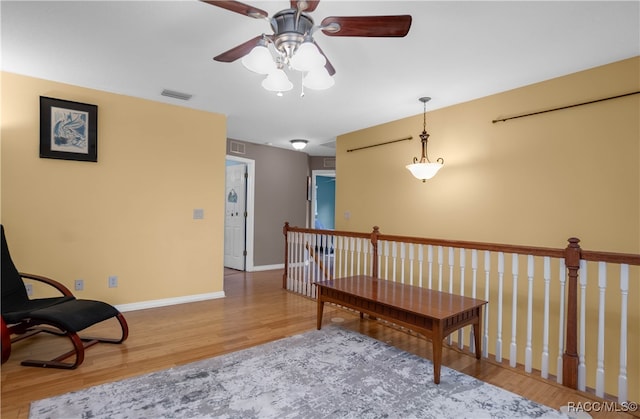 living area with hardwood / wood-style flooring and ceiling fan