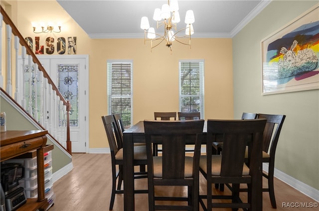 dining area featuring light hardwood / wood-style floors, an inviting chandelier, and crown molding