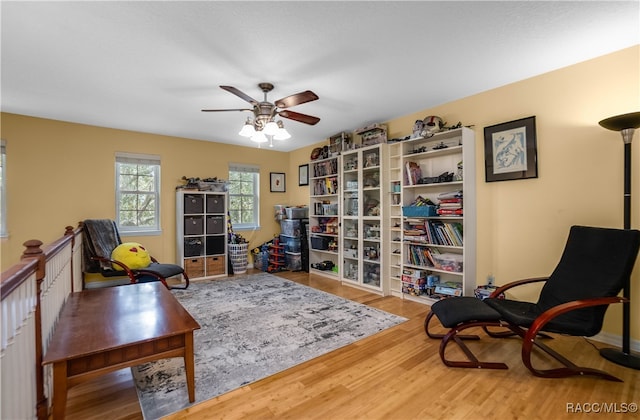 living area featuring wood-type flooring and ceiling fan