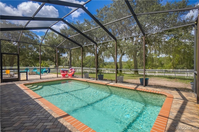 view of swimming pool with glass enclosure and a patio