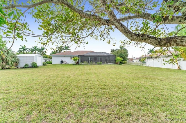 view of yard featuring a lanai and a storage shed